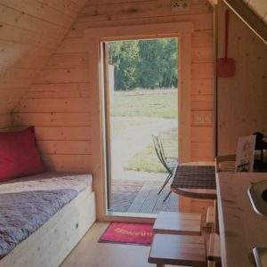 Cabane en bois cosy avec vue sur la nature et un coin repas lumineux.