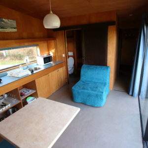 Hébergement insolite en Basse-Normandie : intérieur moderne avec cuisine et coin salon.