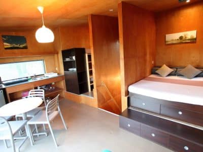 Hébergement insolite en Basse-Normandie, chambre moderne avec bois chaleureux et kitchenette.