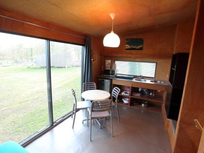 Cabane moderne en bois avec vue sur la nature, lumineuse et cosy.