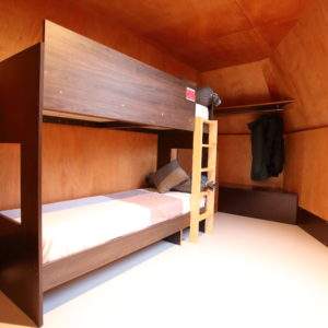 Cabane en bois à Basse-Normandie, avec lit superposé et ambiance chaleureuse.