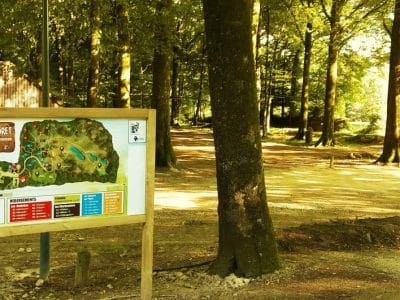 Hébergement insolite en forêt en Basse-Normandie, avec un panneau dactivités coloré.