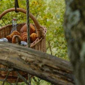 Panier suspendu avec des viennoiseries, hébergement insolite en pleine nature.
