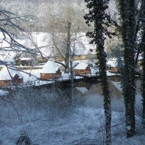 Hébergement insolite en cabanes au bord dun lac, entouré de neige et de nature.
