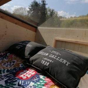 Cocon en bois avec vue panoramique, coussins confortables, idéal pour un séjour insolite.