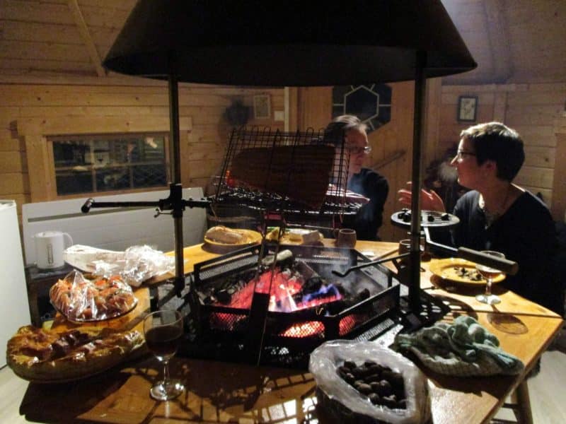 Chalet chaleureux avec cheminée, convives partageant un repas convivial.