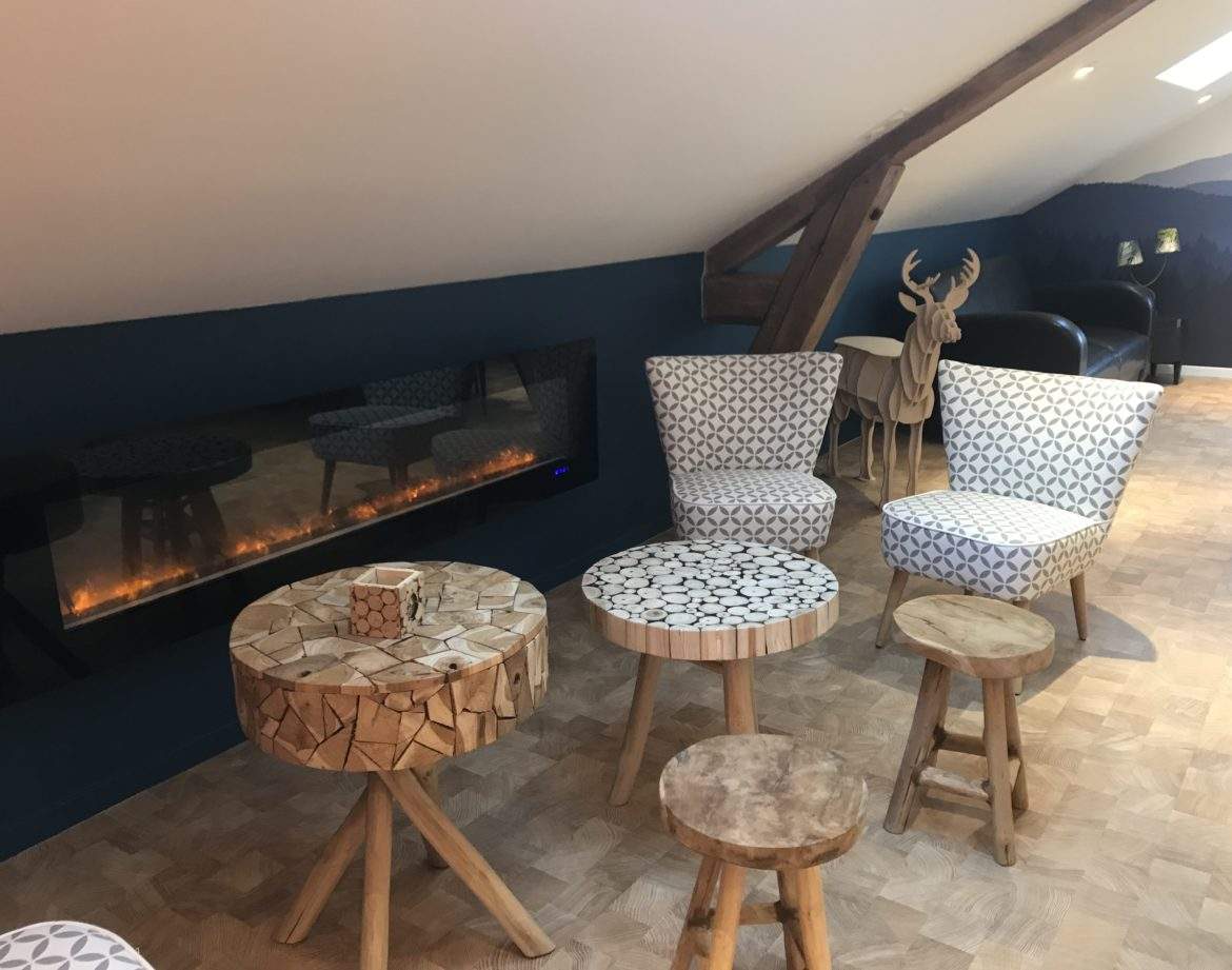 Hébergement insolite en Auvergne-Rhône-Alpes avec fauteuils modernes et cheminée design.