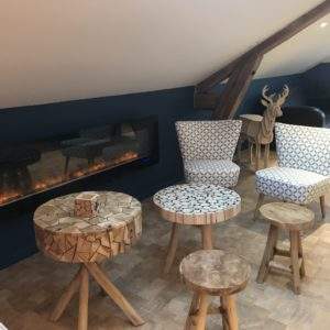 Hébergement insolite en Auvergne-Rhône-Alpes avec fauteuils modernes et cheminée design.