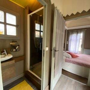 Hébergement insolite en cabane, avec salle de bain moderne et décoration chaleureuse.