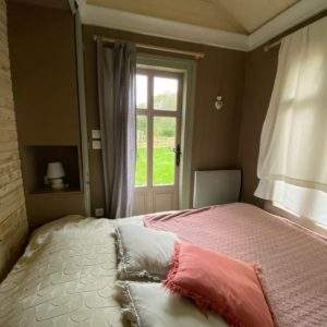 Chalet cosy en Basse-Normandie avec vue sur la nature depuis la fenêtre.