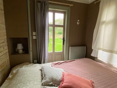 Chalet cosy en Basse-Normandie avec vue sur la nature depuis la fenêtre.