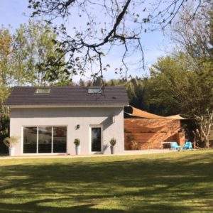 Hébergement insolite en Auvergne-Rhône-Alpes, maison moderne avec grandes baies vitrées.