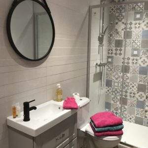 Salle de bain moderne dun hébergement insolite en Auvergne-Rhône-Alpes, avec carrelage coloré.