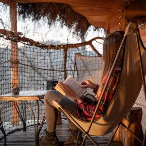 Hébergement insolite en cabane, avec une vue apaisante et un coin lecture cosy.