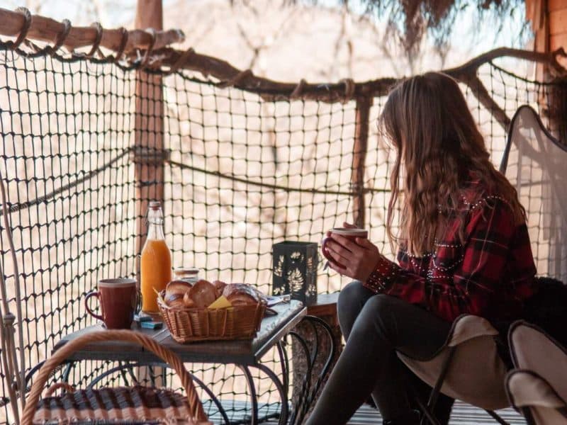 Cabane dans les arbres avec vue, petit-déjeuner sur la terrasse en bois.