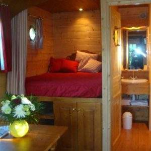 Cabane en bois cosy avec lit double et décoration chaleureuse à Pays de la Loire.