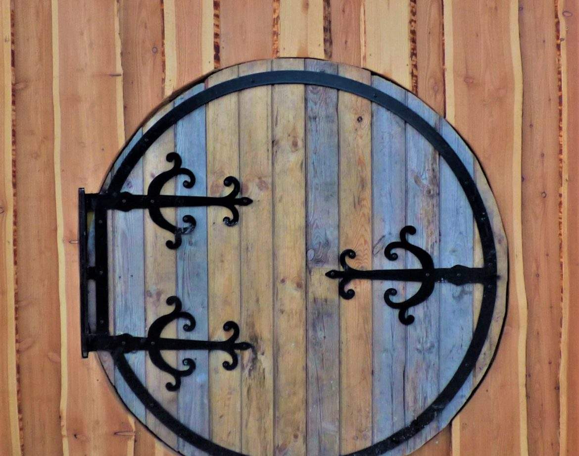 Porte ronde en bois dun hébergement insolite en Auvergne, alliant charme et originalité.