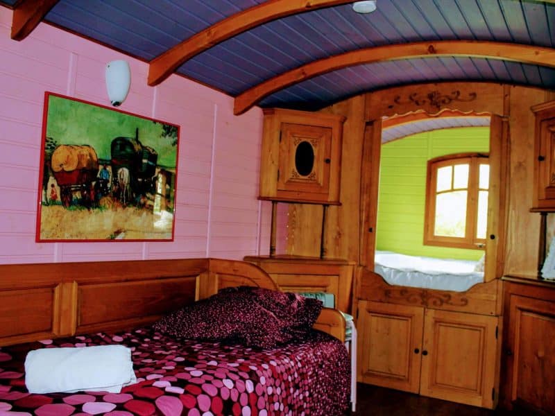 Chalet coloré avec lit douillet et décoration en bois chaleureux.