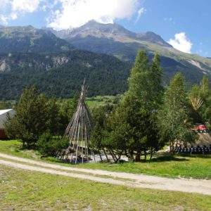 Tentes tipi au milieu de la nature, avec montagnes en arrière-plan en Auvergne-Rhône-Alpes.