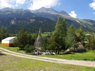 Tentes tipi au milieu de la nature, avec montagnes en arrière-plan en Auvergne-Rhône-Alpes.