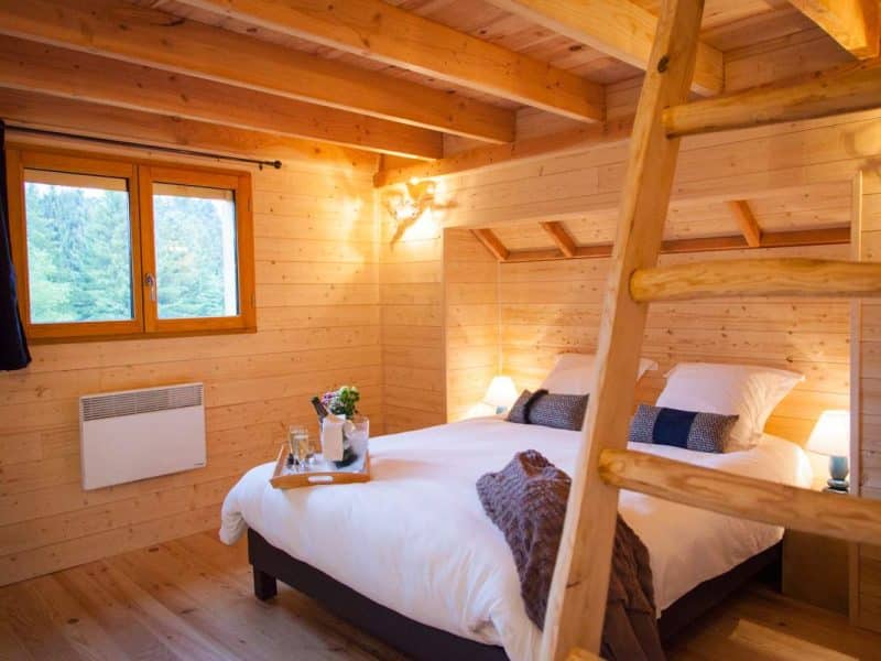 Chalet en bois chaleureux avec lit double et vue sur la nature.