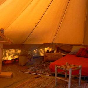 Tente safari confortable avec lit douillet et décor coloré, idéale pour un séjour insolite.