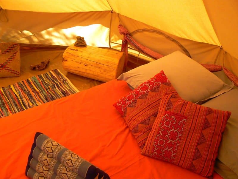 Tente confortable en Languedoc-Roussillon, avec un lit douillet et des coussins colorés.