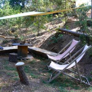 Hébergement insolite en Languedoc-Roussillon avec chaises longues et coin détente naturel.