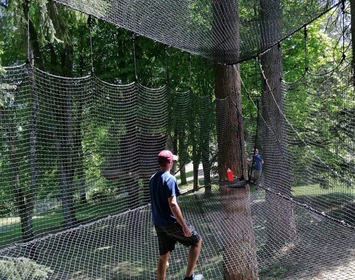Filet suspendu entre les arbres, offrant une expérience unique en pleine nature.