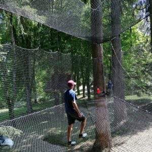Filet suspendu entre les arbres, offrant une expérience unique en pleine nature.