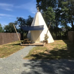 Tente tipie spacieuse avec terrasse, entourée de verdure au Pays de la Loire.