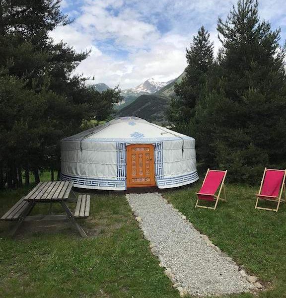 Yourte spacieuse en pleine nature, entourée de verdure et avec vue sur les montagnes.