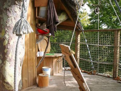 Cabane dans les arbres en Basse-Normandie, avec un espace en bois et une vue sur la nature.