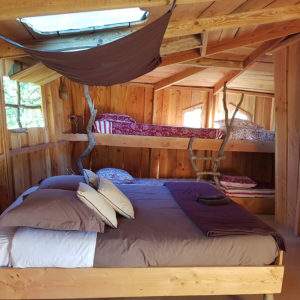 Cabane en bois cosy avec lits superposés et décoration naturelle.