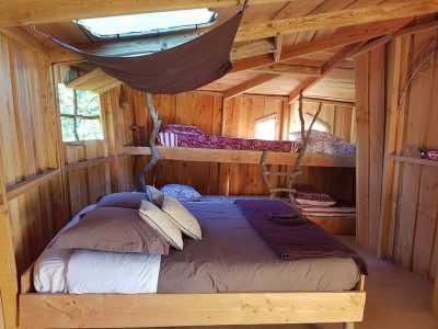 Cabane en bois cosy avec lits superposés et décoration naturelle.
