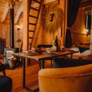 Cabane en bois chaleureuse avec un coin salon cosy et une décoration naturelle.