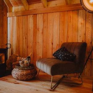 Cabane en bois chaleureuse avec un coin salon et un poêle à bois.