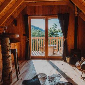 Cabane en bois avec vue sur la nature, intérieur chaleureux et lumineux.