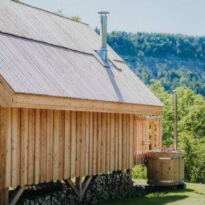 Cabane en bois avec un bain nordique, entourée de verdure en Provence-Alpes-Côte dAzur.