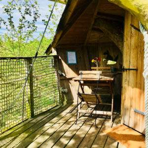 Cabane perchée en Basse-Normandie avec terrasse en bois et vue sur la nature.