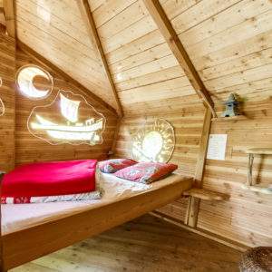 Cabane en bois avec lit douillet et fenêtres originales à Pays de la Loire.