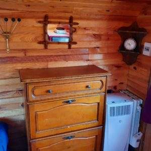 Cabane en bois cosy avec un mobilier vintage et des rideaux violets.