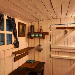 Cabane en bois au Centre, avec des murs blancs et des rideaux fleuris.