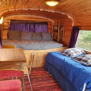 Hébergement insolite : charmante roulotte en bois avec lit douillet et décor chaleureux.