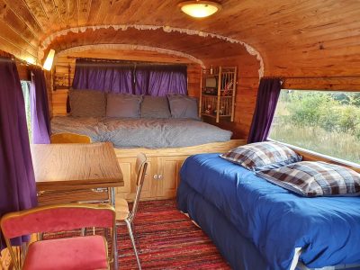 Hébergement insolite : charmante roulotte en bois avec lit douillet et décor chaleureux.
