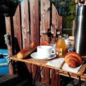 Petit-déjeuner sur une terrasse en bois, avec vue sur un canoë à Pays de la Loire.