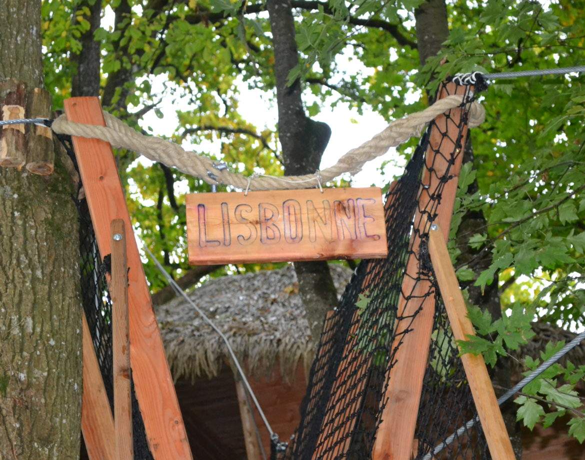 Cabane dans les arbres à Pays de la Loire, avec un panneau en bois Lisbonne.