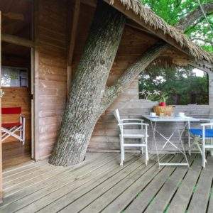 Cabane dans les arbres en Pays de la Loire, avec terrasse en bois et vue sur la nature.