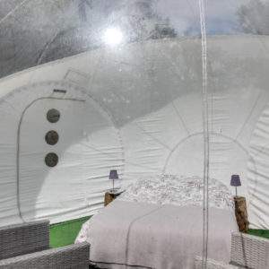 Dôme transparent avec lit douillet et chaises en osier, au cœur des Pays de la Loire.