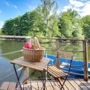 Cabane flottante à Pays de la Loire, avec vue sur le lac et une table en bois.